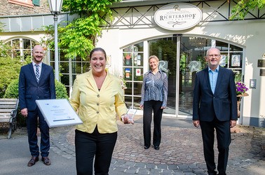 Motiv: IHK-Mitarbeiter überreichen einer Vertreterin des Weinromantikhotels Richtershof die Auszeichnung "Hervorragender Ausbildungsbetrieb". (Foto: IHK Trier)