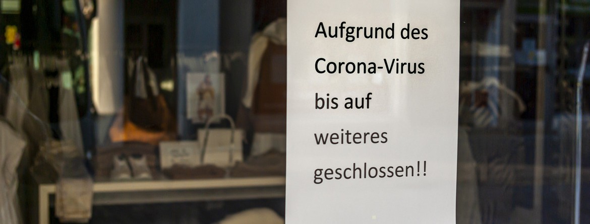 Motiv: Im Schaufenster eines Bekleidungsgeschäfts hängt ein Zettel mit der Aufschrift "Aufgrund des Coronavirus bis auf weiteres geschlossen!!" (Foto: Marc Bode - stock.adobe.com)