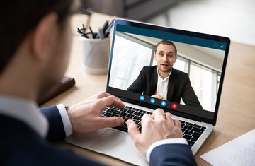 Mann sitzt vor einem Bildschirm im Online Meeting(Foto: Fizkes - stockadobe.com)